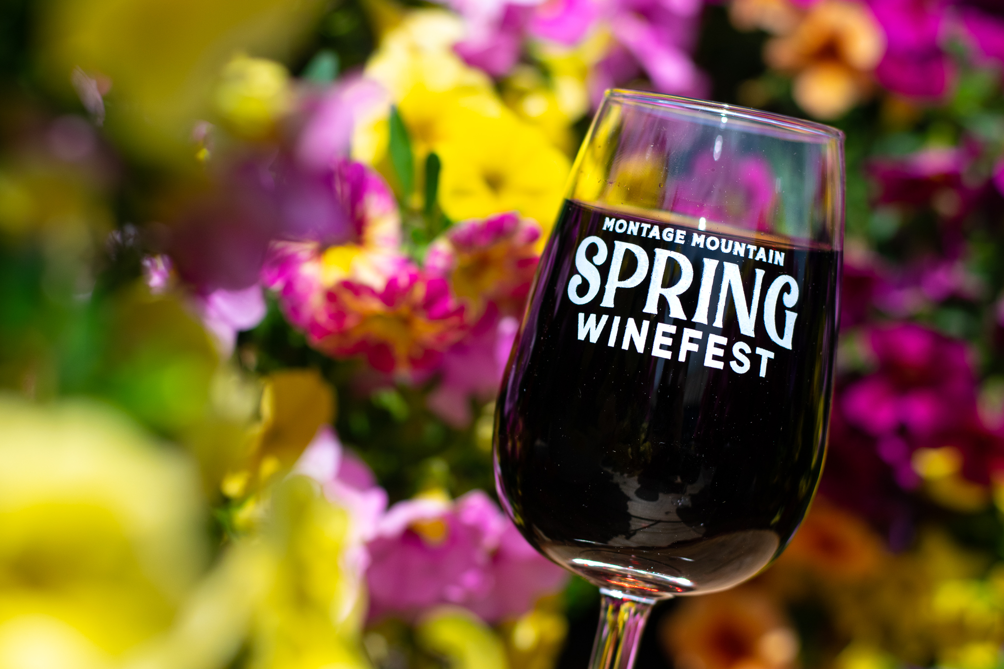 Spring Winefest glass surrounded by colorful flowers